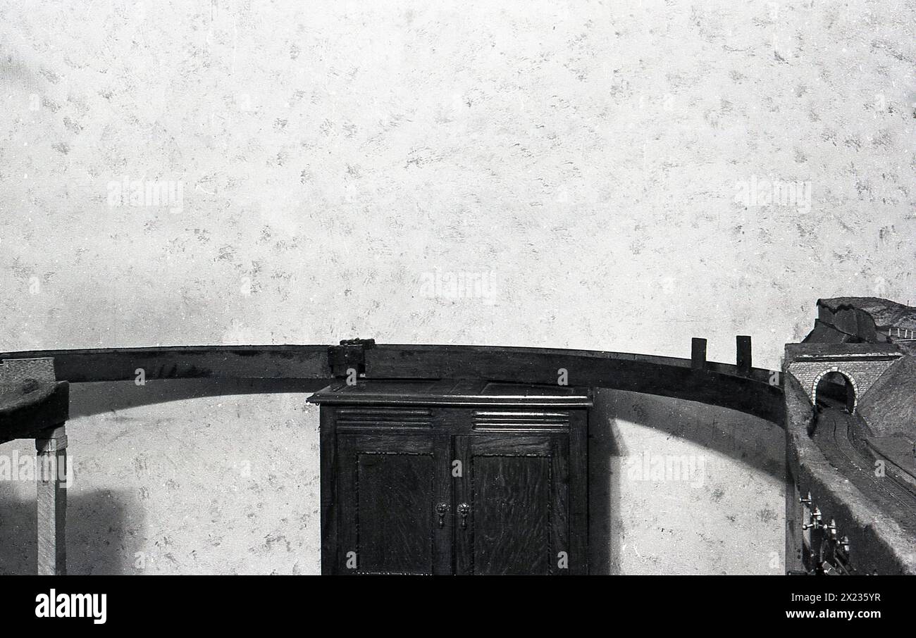 1960, storica ferrovia domestica, l'immagine mostra una sezione del binario ferroviario seduto sulla parte superiore di un armadietto di legno, Inghilterra, Regno Unito. Foto Stock