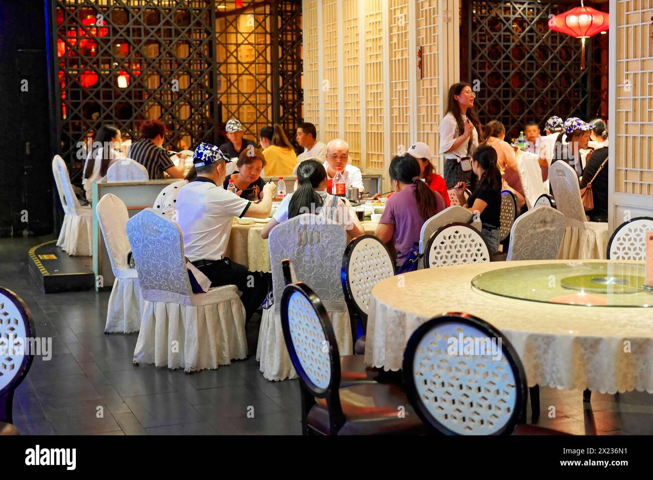 Cena al raffinato ristorante di Shanghai, Cina, Asia, persone che si godono un pasto sulla terrazza del ristorante circondata da eleganza e luce soffusa, Shanghai Foto Stock