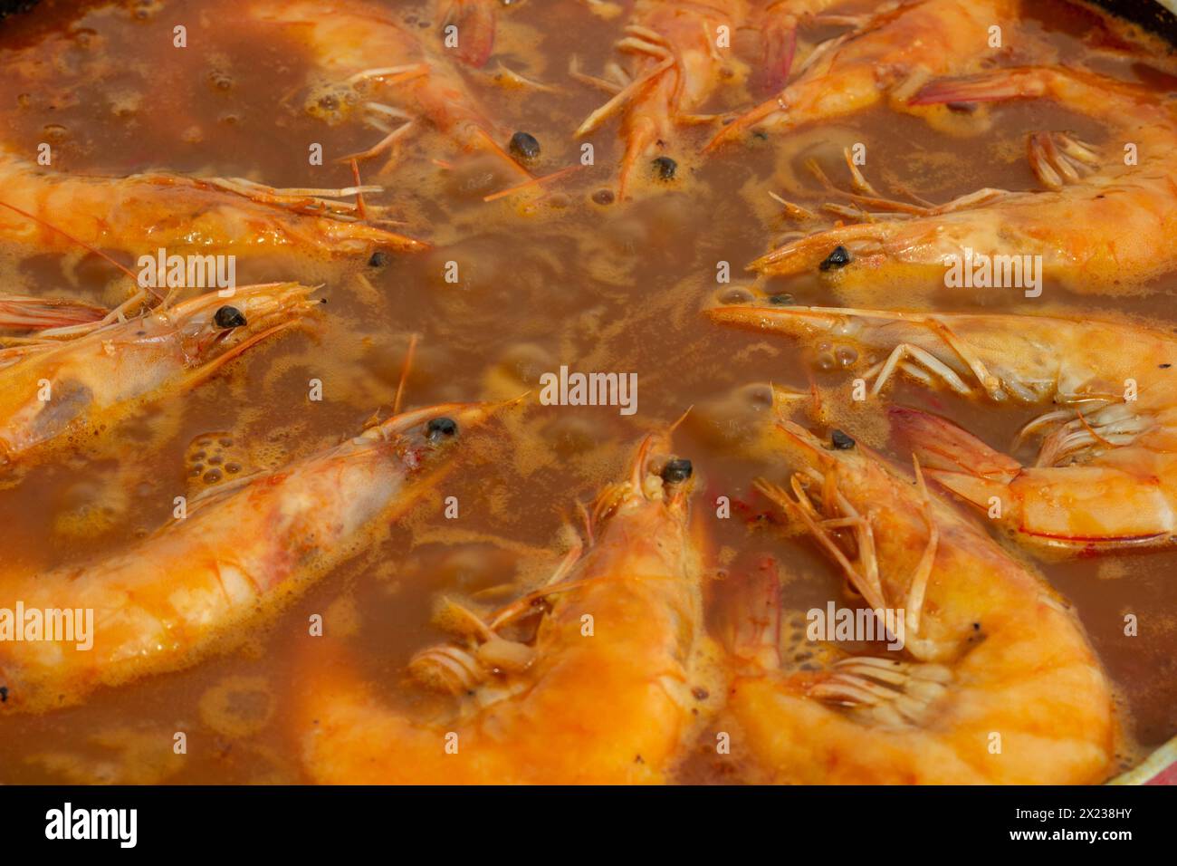 Sperimentate l'armonia culinaria mentre i gamberi fritti dorati si uniscono alla vibrante miscela di sapori della tradizionale paella spagnola, arricchendo ogni boccone con la S. Foto Stock