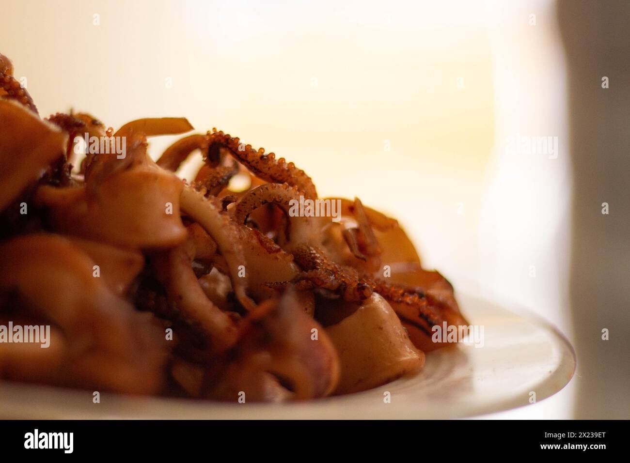 Viziatevi con la perfezione croccante dei calamari fritti dorati, un'allettante specialità di pesce che promette di deliziare le vostre papille gustative con ogni pezzo croccante Foto Stock