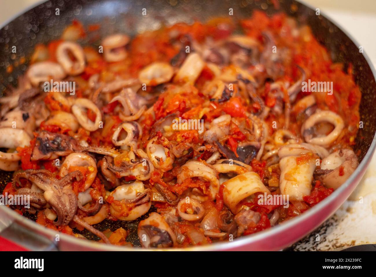 Tuffati nell'essenza della cucina spagnola con succulenti calamari sofrito, pronti a portare la tua paella alla perfezione Foto Stock