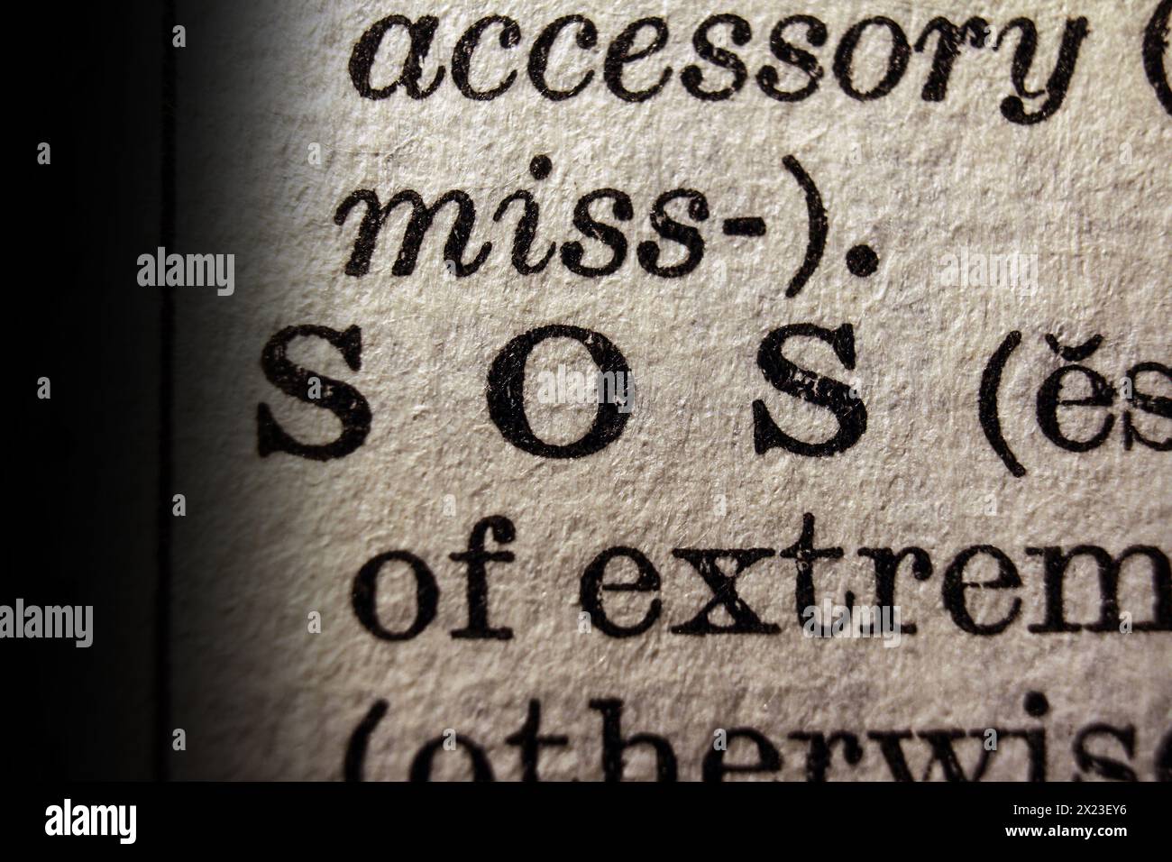 Word SOS sulla pagina del dizionario, primo piano della macro Foto Stock