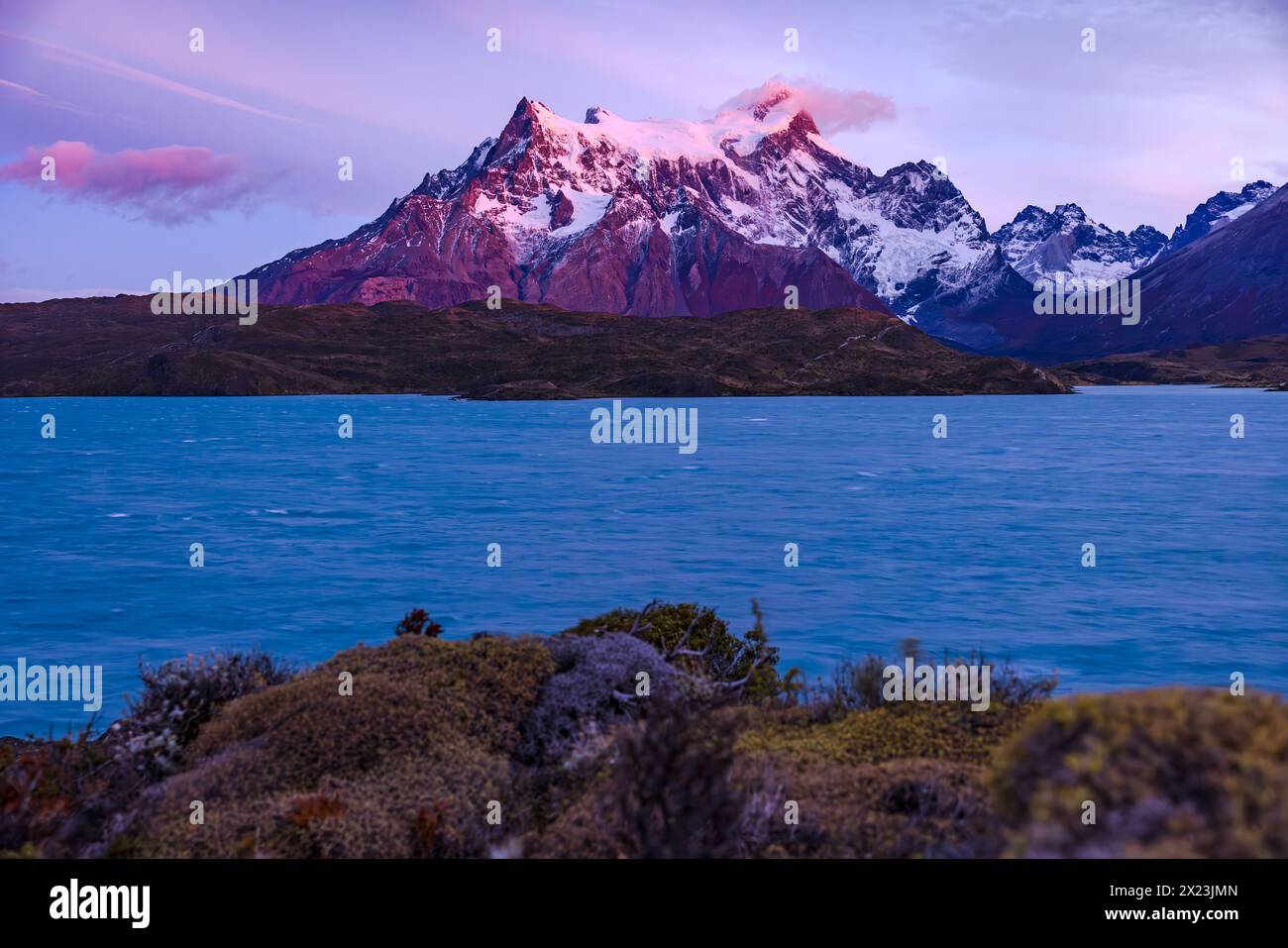 Alba sulla cima innevata del Cerro Paine grande dietro il lago Pehoe, il Parco Nazionale Torres del Paine, Cile, Patagonia, Sud America Foto Stock