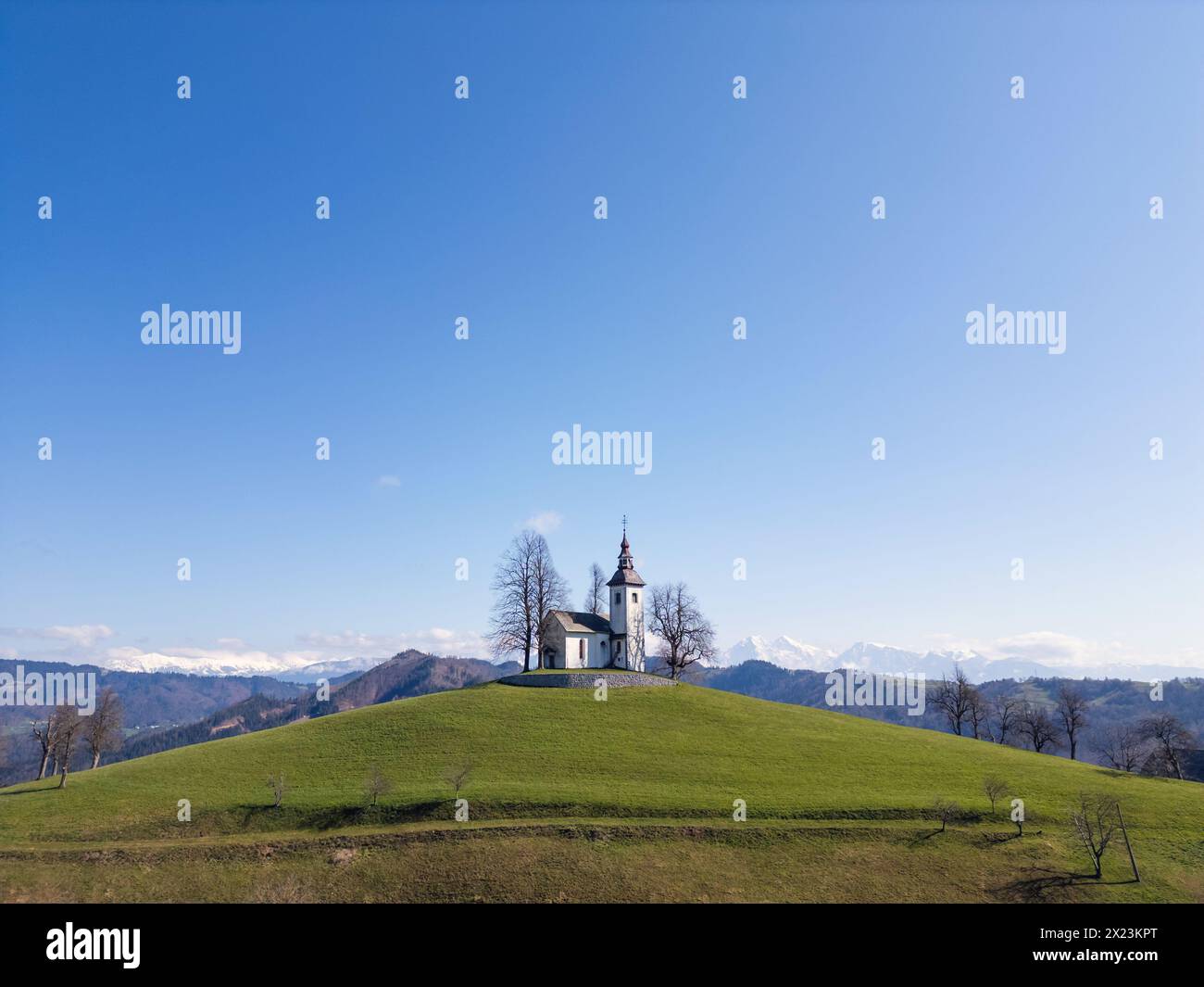 Splendida vista panoramica delle Alpi Giulie con l'iconica chiesa di San Tommaso in Slovenia, colpo di droni. Concetti di viaggio, natura e luoghi di interesse. Foto Stock