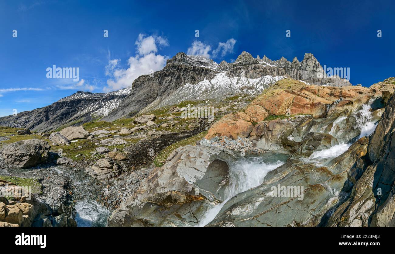 Panorama con cascata che scorre su lastre di roccia rossa, Tschingelhörner sullo sfondo, Plaun Segnas Sut, Unterer Segnesboden, Sardona Tectonic Arena, Foto Stock