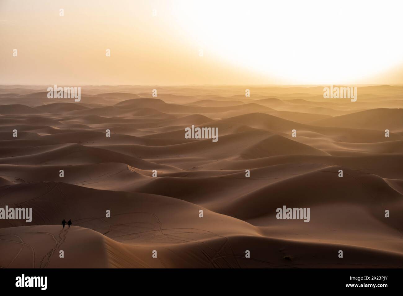 Una coppia nelle dune di sabbia a Erg Chigaga, in Marocco Foto Stock