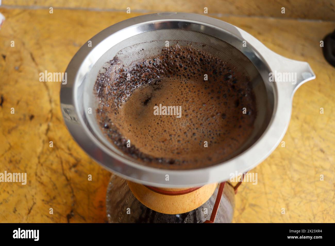 Versare il bicchiere sulla macchina per il caffè su piastrelle in ceramica. Shot verticale, completo, nessuno, versare sulla macchina per il caffè con caffè appena estratto Foto Stock