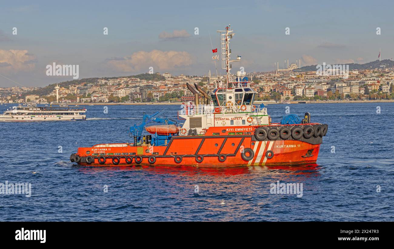 Istanbul, Turchia - 19 ottobre 2023: Rimorchiatore rosso presso la nave di sicurezza costiera del Canale del Bosforo, Sunny Autumn Day. Foto Stock