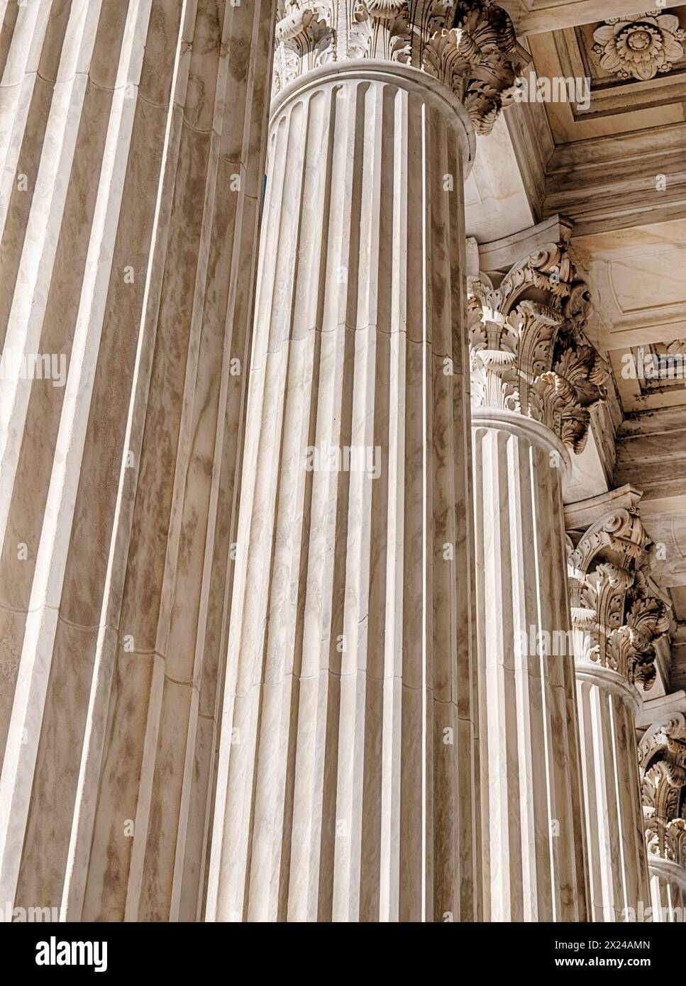Le alte colonne di marmo di fronte alla Corte Suprema degli Stati Uniti sono illuminate dalla luce del sole e proiettano un senso di giustizia. Foto Stock