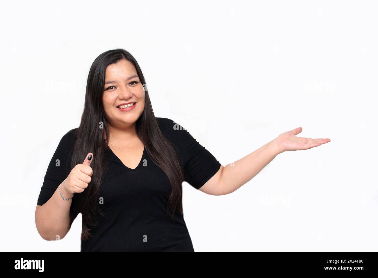 Una donna adulta latina mostra eccitatamente il suo pollice inchiodato dopo aver esercitato il suo voto libero e segreto in Messico Foto Stock