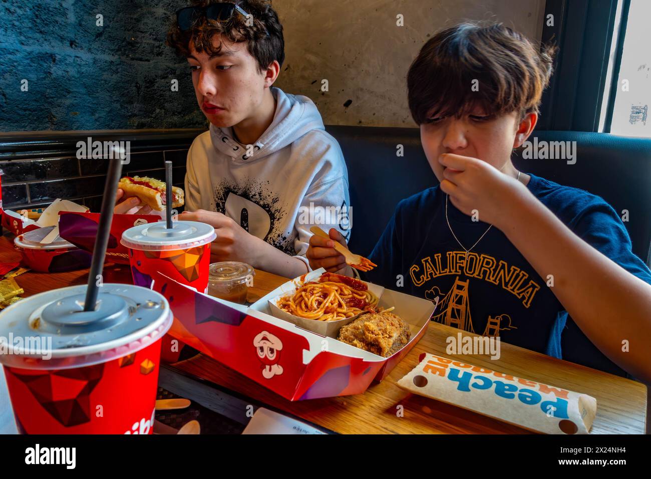 Una famiglia condivide un pasto a base di pollo fritto in un ristorante Jollibee a Reading, Regno Unito Foto Stock