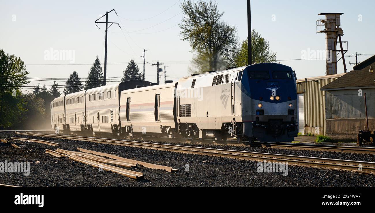 Monroe, Washington, Stati Uniti - 17 aprile 2024; il treno passeggeri Amtrak Empire Builder brilla mentre si dirige a est lontano dal sole del tramonto Foto Stock