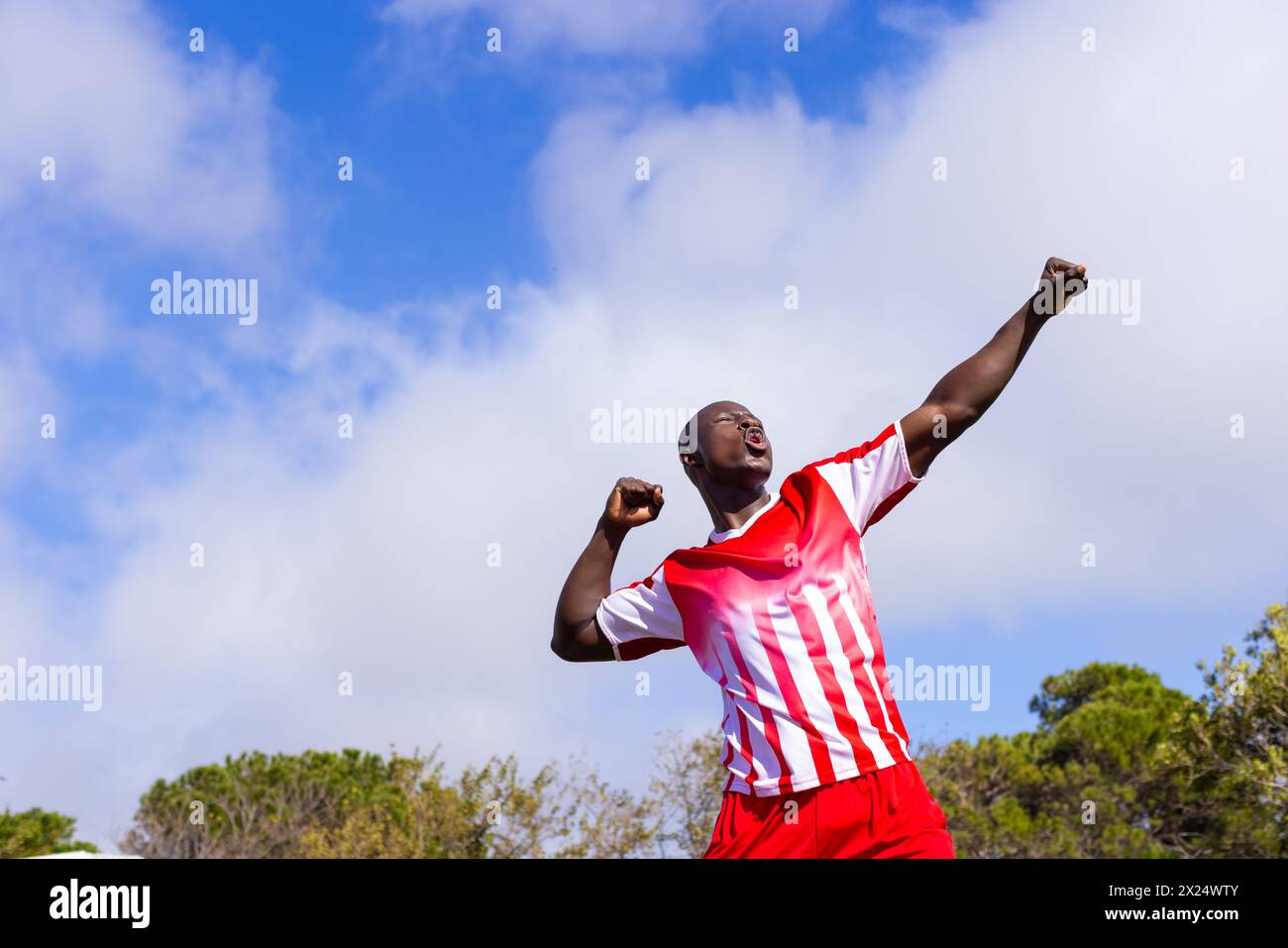 Giovane atleta afroamericano che celebra la vittoria sul campo all'aperto, copia spazio Foto Stock