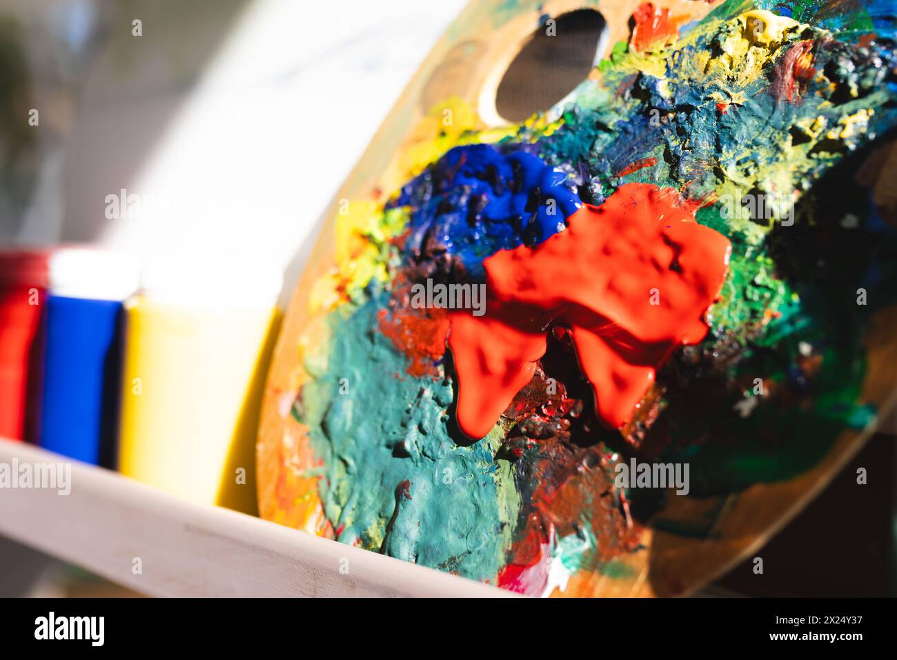 I colori brillanti si fondono su una tavolozza ben utilizzata a casa, suggerendo la creatività in corso Foto Stock
