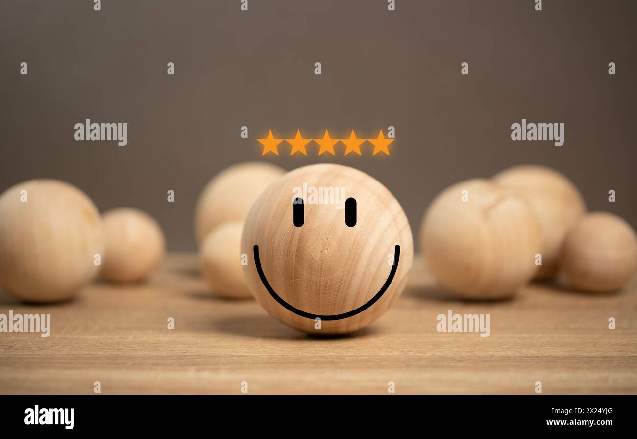 concetto di soddisfazione del cliente. icona sorriso sulla palla di legno sul tavolo. servizio clienti la migliore esperienza di valutazione aziendale. Satisfactio Foto Stock