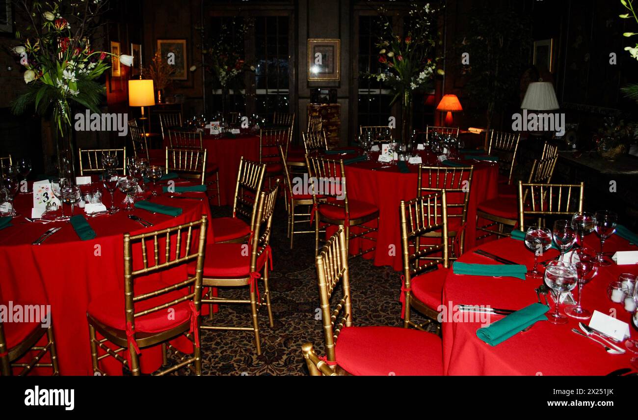 Tavoli da pranzo con tovaglie rosse, tovaglioli verdi e sedie da ballo dorate per una cena di Natale con catering a New York City, USA Foto Stock