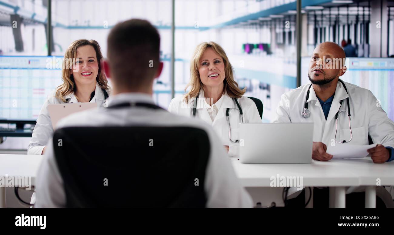 Giovani medici felici che parlano tra loro in ufficio Foto Stock