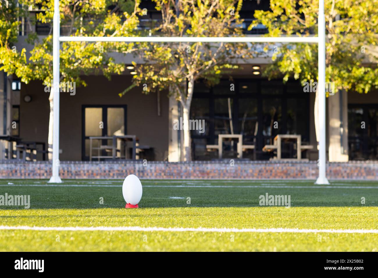 Una palla da rugby appoggiata sul tee, pronta per un calcio d'inizio in campo all'aperto, spazio copia Foto Stock