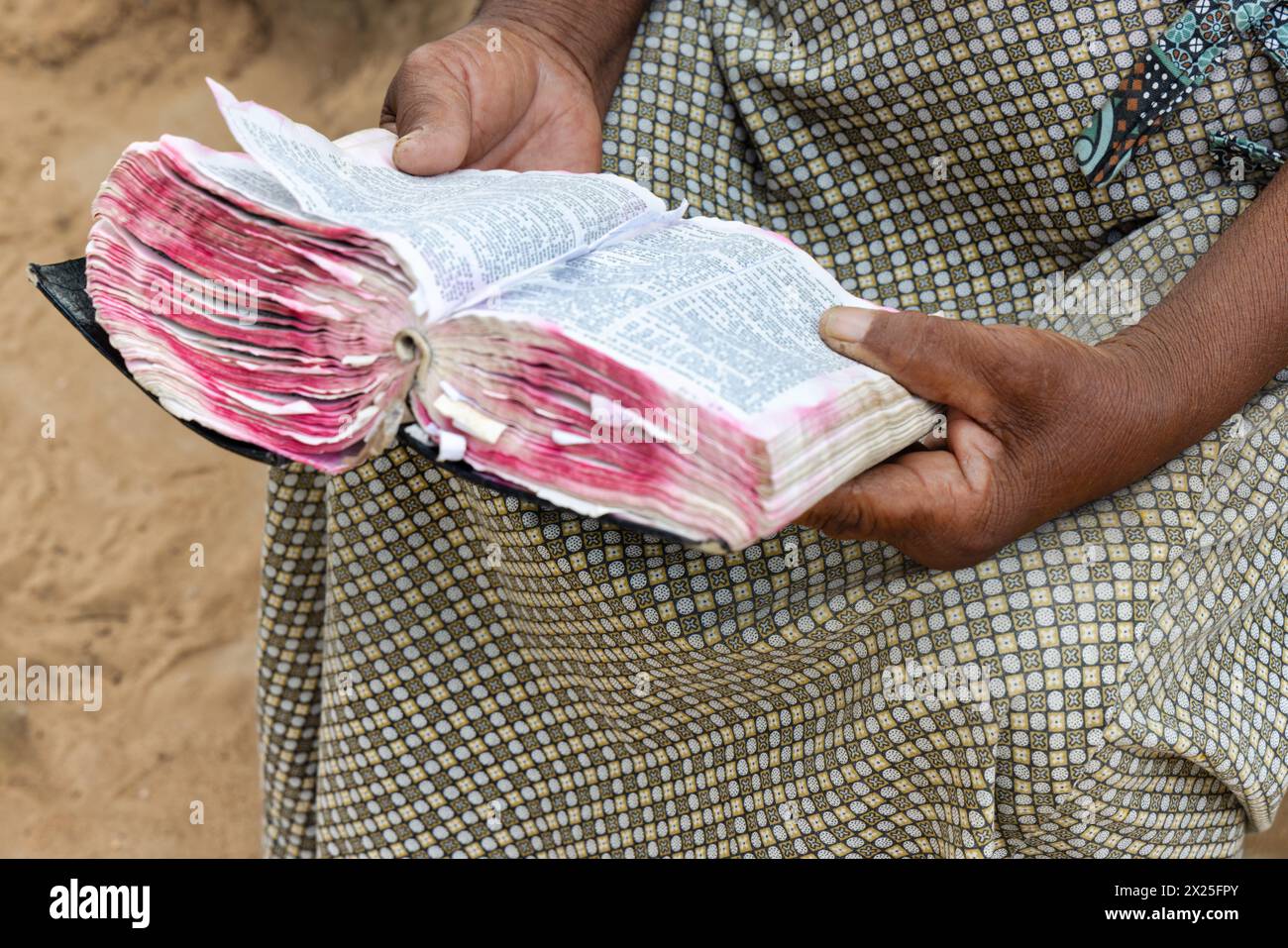 Vecchia donna africana cristiana del villaggio, che legge un libro sacro della bibbia, vestito casual Foto Stock