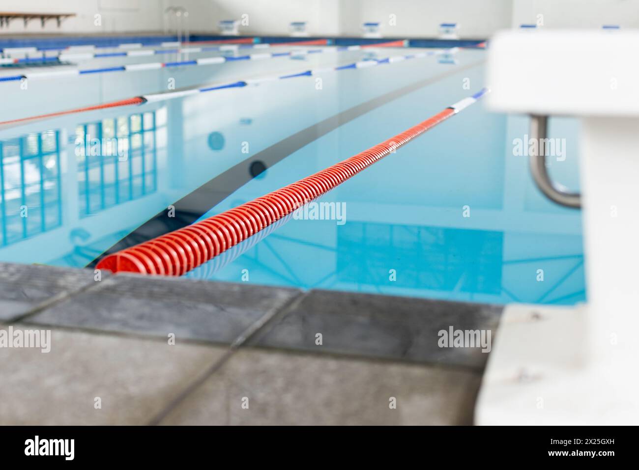 I nuotatori che indossano cappellini e occhiali di protezione corrono in una piscina coperta e in uno spazio per fotocopie Foto Stock