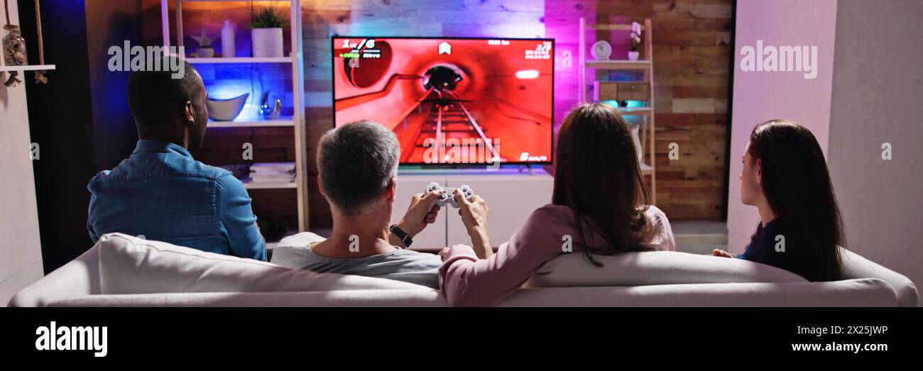 Famiglia che gioca a videogiochi in televisione, persone che guardano la TV. Foto Stock