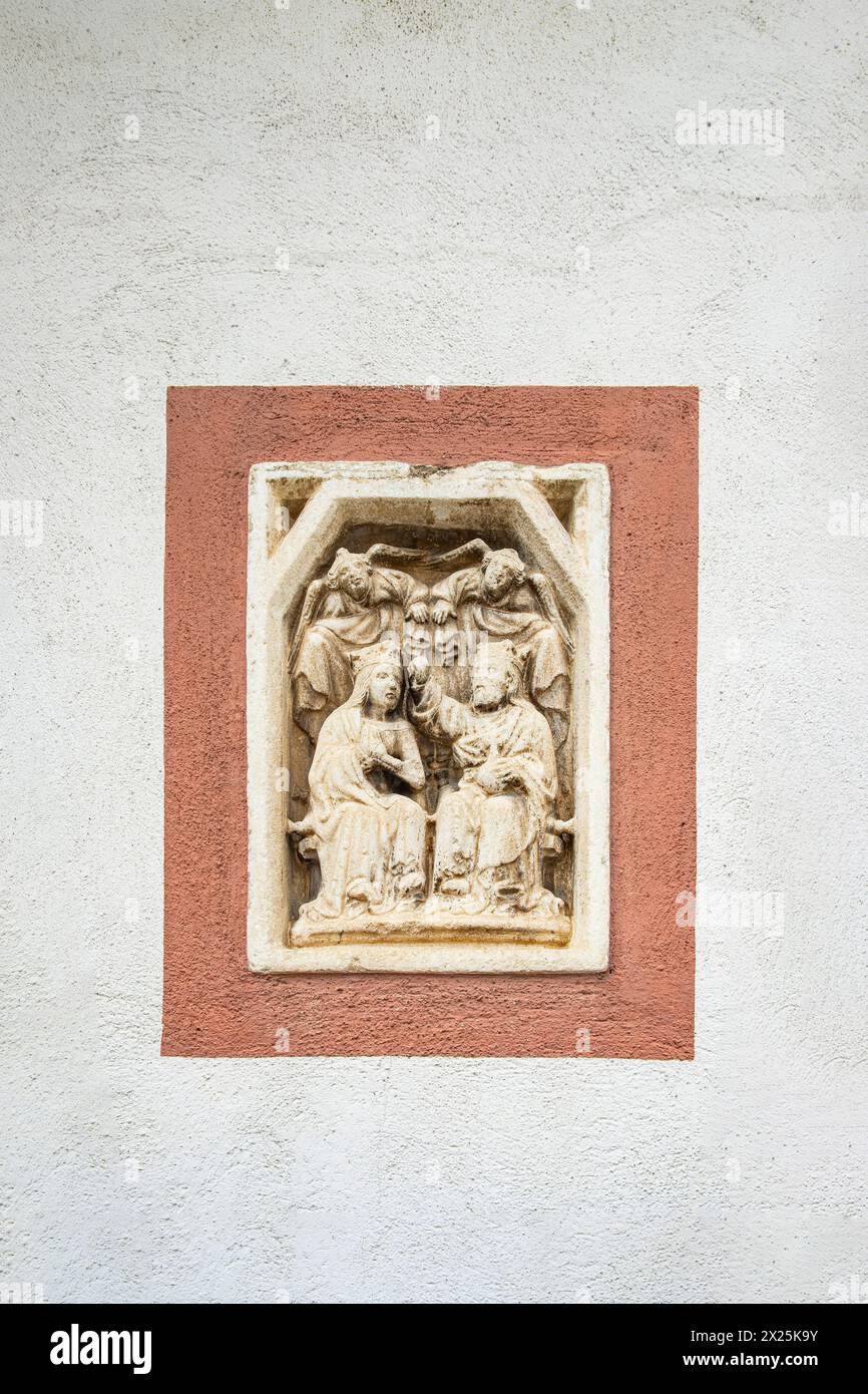 Sogenanntes Interessantes Marmorrelief mit der Darstellung der Marienkrönung von um 1400 an der Nordseite des Mesnerhauses a scena (scena), Südtiro Foto Stock