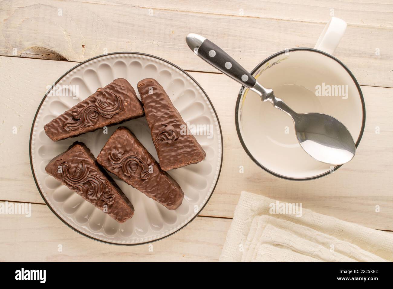 Diversi pezzi di torta al cioccolato con piatto in ceramica e tazza su un tavolo in legno, vista dall'alto Foto Stock