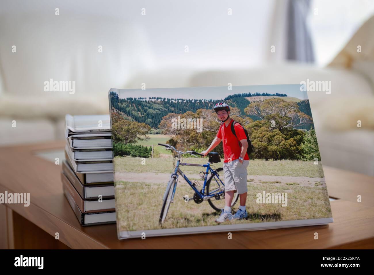 Libro fotografico di viaggi in famiglia con pile di album fotografici sul tavolino da caffè. Foto Stock