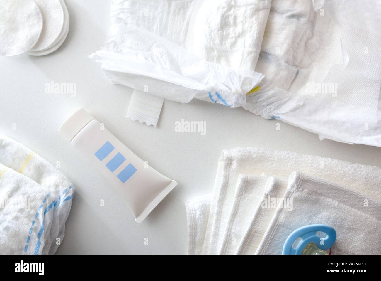 Accessori blu per cambiare il pannolino e prendersi cura della pelle del bambino con crema e talco in polvere. Vista dall'alto. Foto Stock