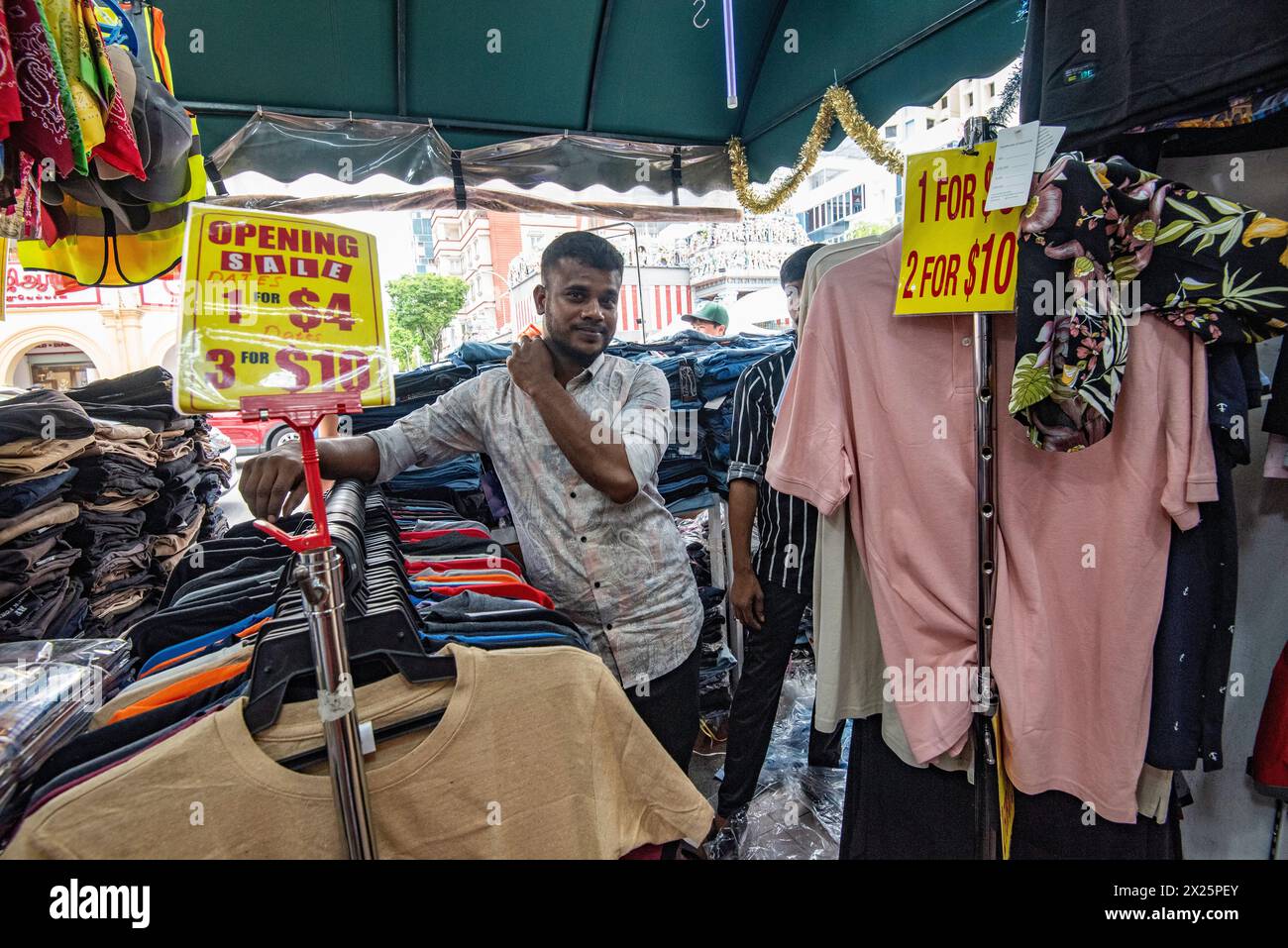 Due uomini che lavorano in un negozio di abbigliamento al mercato di Campbell Lane nel quartiere Little India della città di Singapore di domenica Foto Stock