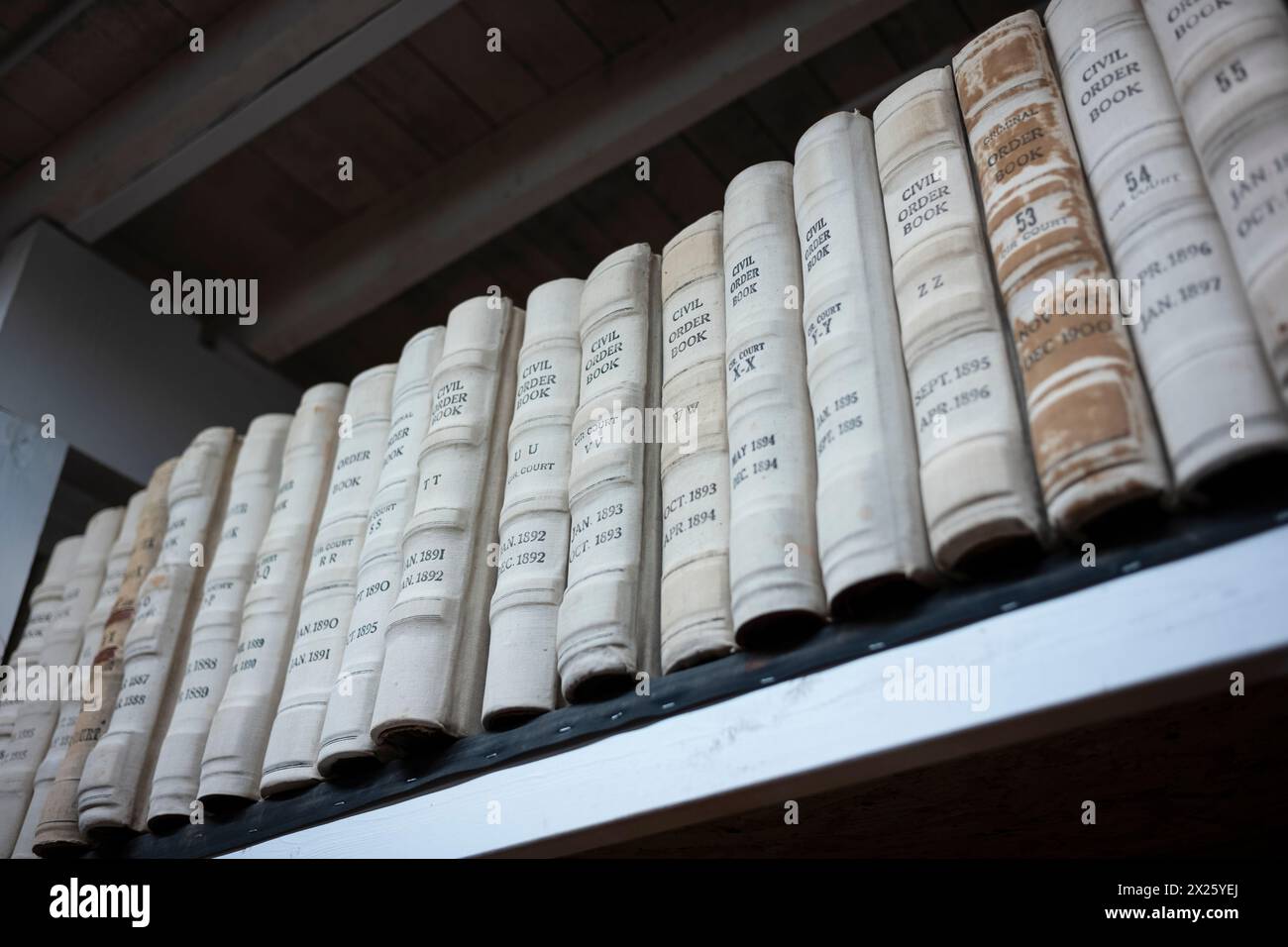 Le pile di libri contenenti documenti pubblici sono ordinatamente organizzate su una libreria che si trova nella biblioteca pubblica. Foto Stock