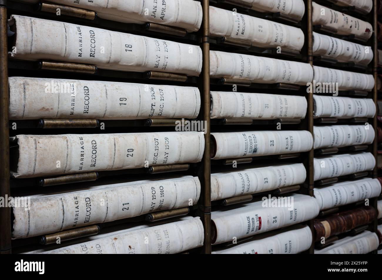 Le pile di libri contenenti documenti pubblici sono ordinatamente organizzate su una libreria che si trova nella biblioteca pubblica. Foto Stock