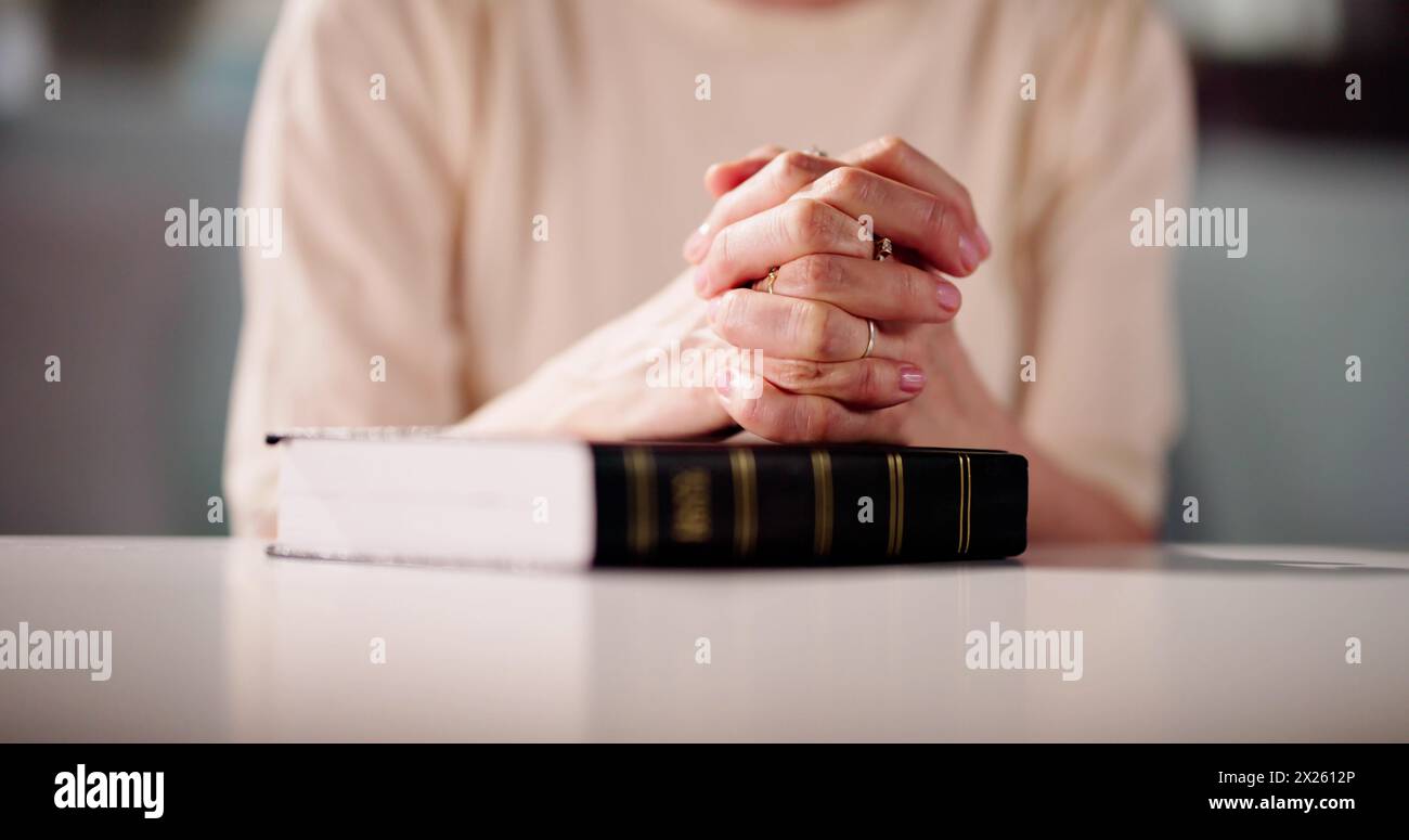 La mano della donna sul Libro della Bibbia. Preghiera cristiana Foto Stock