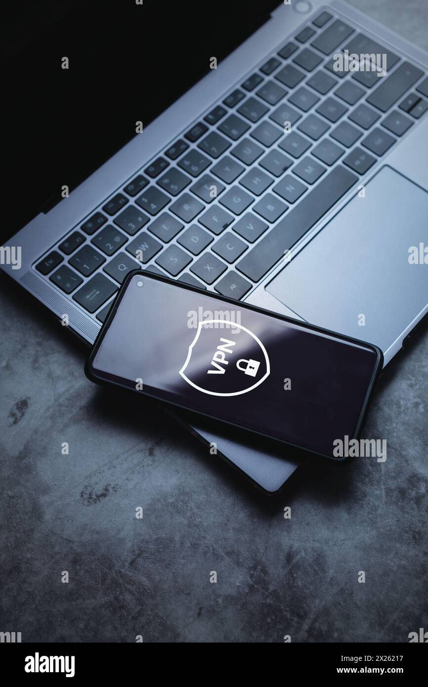 Smartphone posizionato su un laptop con creazione di app VPN. Protocolli Internet per la protezione dei dati di rete privata. Foto Stock