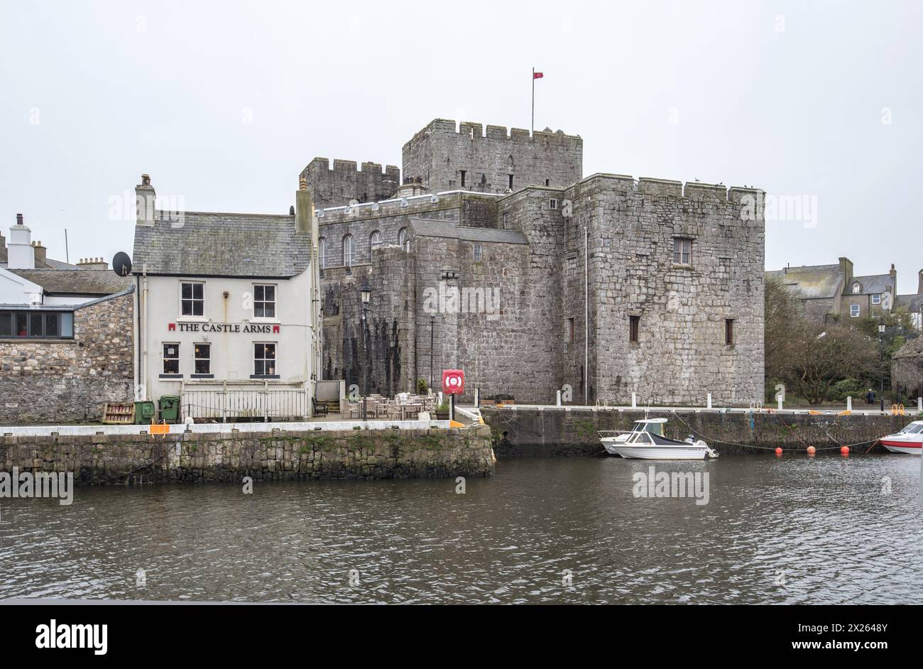 Le mura del castello di Rushen si affacciano sull'area del porto mareale di Castletown, Isola di Man. Foto Stock