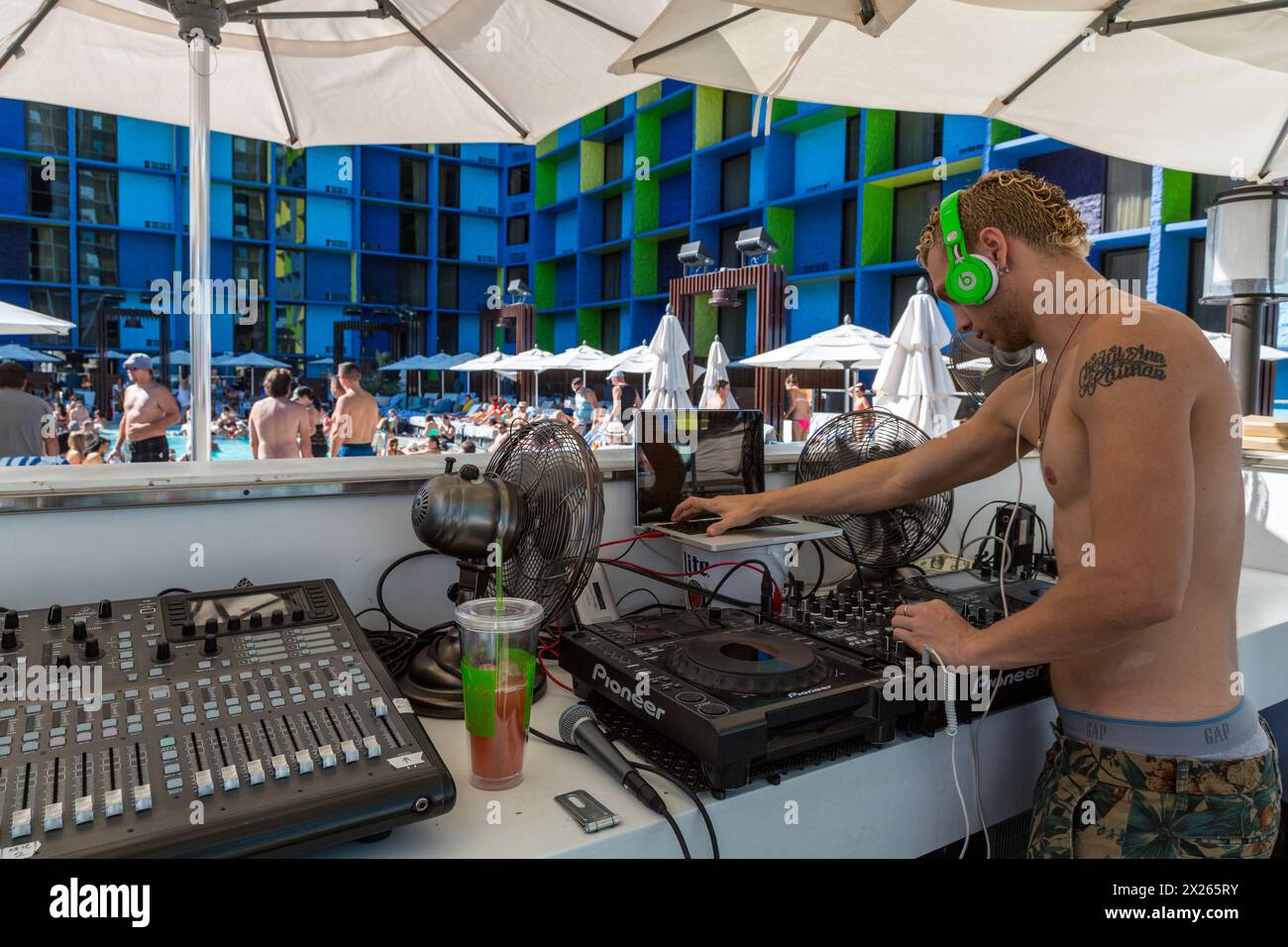 Las Vegas, Nevada. Disk Jockey la gestione della musica intorno alla piscina di LINQ. Nota orecchio anello. Foto Stock