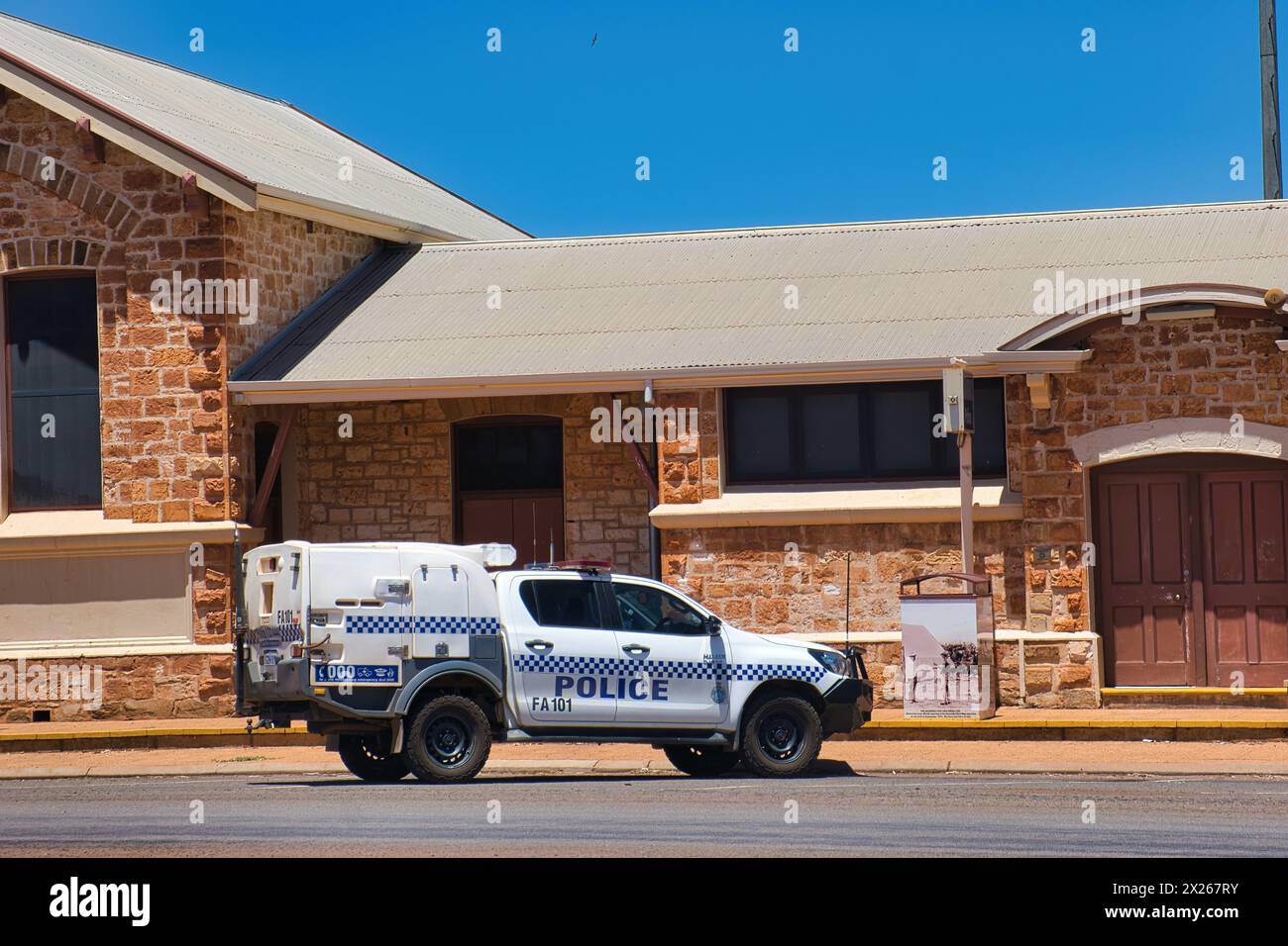 Auto della polizia dell'Australia Occidentale di fronte a un edificio storico nella remota città di Cue Foto Stock