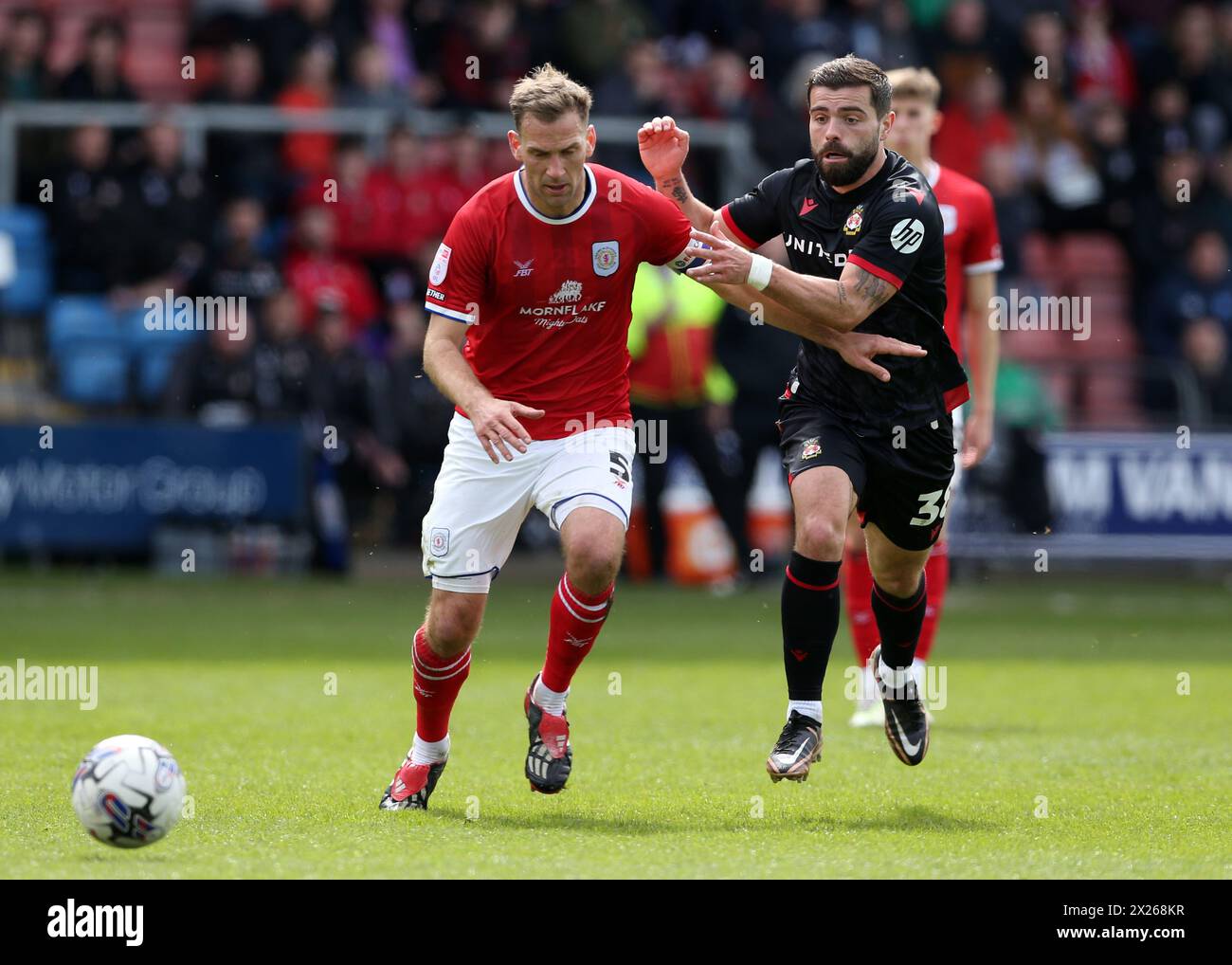 Mickey Demetriou (a sinistra) di Crewe Alexandra e Elliot Lee di Wrexham combattono per il pallone durante la partita Sky Bet League Two al Mornflake Stadium di Crewe. Data foto: Sabato 20 aprile 2024. Foto Stock