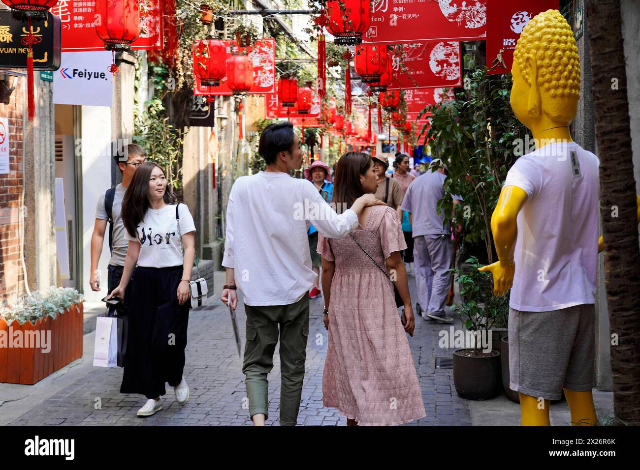 Passeggia attraverso il quartiere restaurato di Tianzifang, Una vivace zona pedonale con decorazioni rosse e una statua, Shanghai, Cina Foto Stock