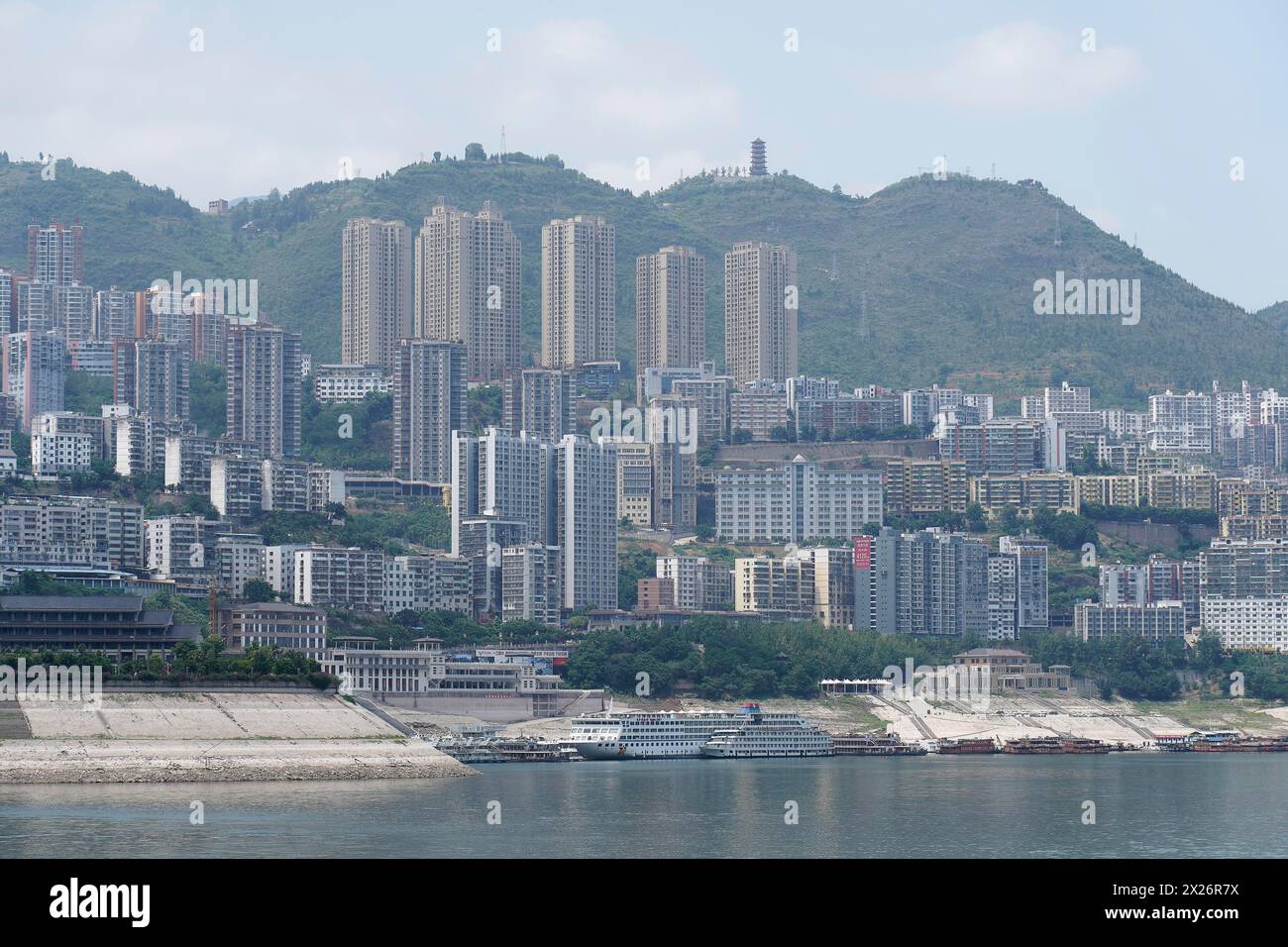 Chongqing, provincia di Chongqing, vista di un paesaggio urbano lungo il fiume con un fitto sviluppo e montagne sullo sfondo, Chongqing, Chongqing Foto Stock