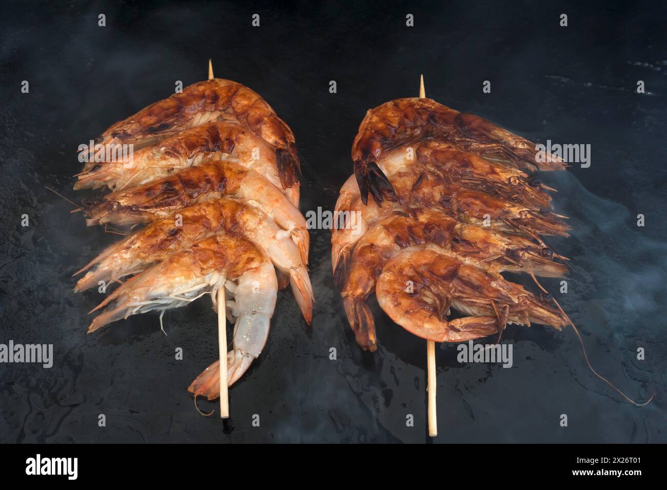 Gamberetti arrostiti sputati su un plancha, barbecue a gas, Vandee, Francia Foto Stock