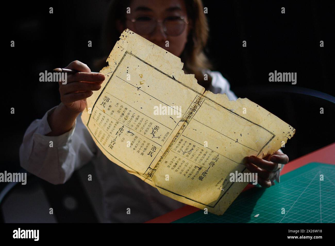 (240420) -- CHANGCHUN, 20 aprile 2024 (Xinhua) -- Zhang Hua, un restauratore di libri antichi nella biblioteca dell'Università di Jilin, osserva i danni delle pagine di un libro antico prima del restauro presso la biblioteca dell'Università Jilin a Changchun, nella provincia di Jilin, nella Cina nord-orientale, 19 aprile 2024. La Jilin University vanta una collezione di quasi 400.000 libri antichi nella sua biblioteca. Secondo Zhang Qi, restauratore di libri antichi nella biblioteca dell'Università di Jilin, la scuola ha eseguito i lavori di restauro di libri antichi fin dagli anni '1950, che non è mai stato interrotto per decad Foto Stock