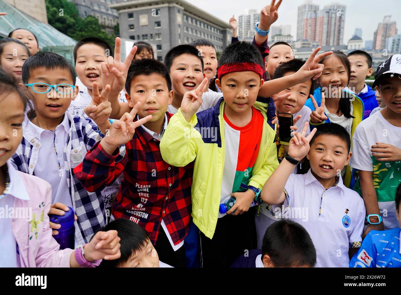 Chongqing, provincia di Chongqing, Cina, Asia, gruppo di studenti in abiti colorati mostrano gesti gioiosi durante una gita scolastica Foto Stock