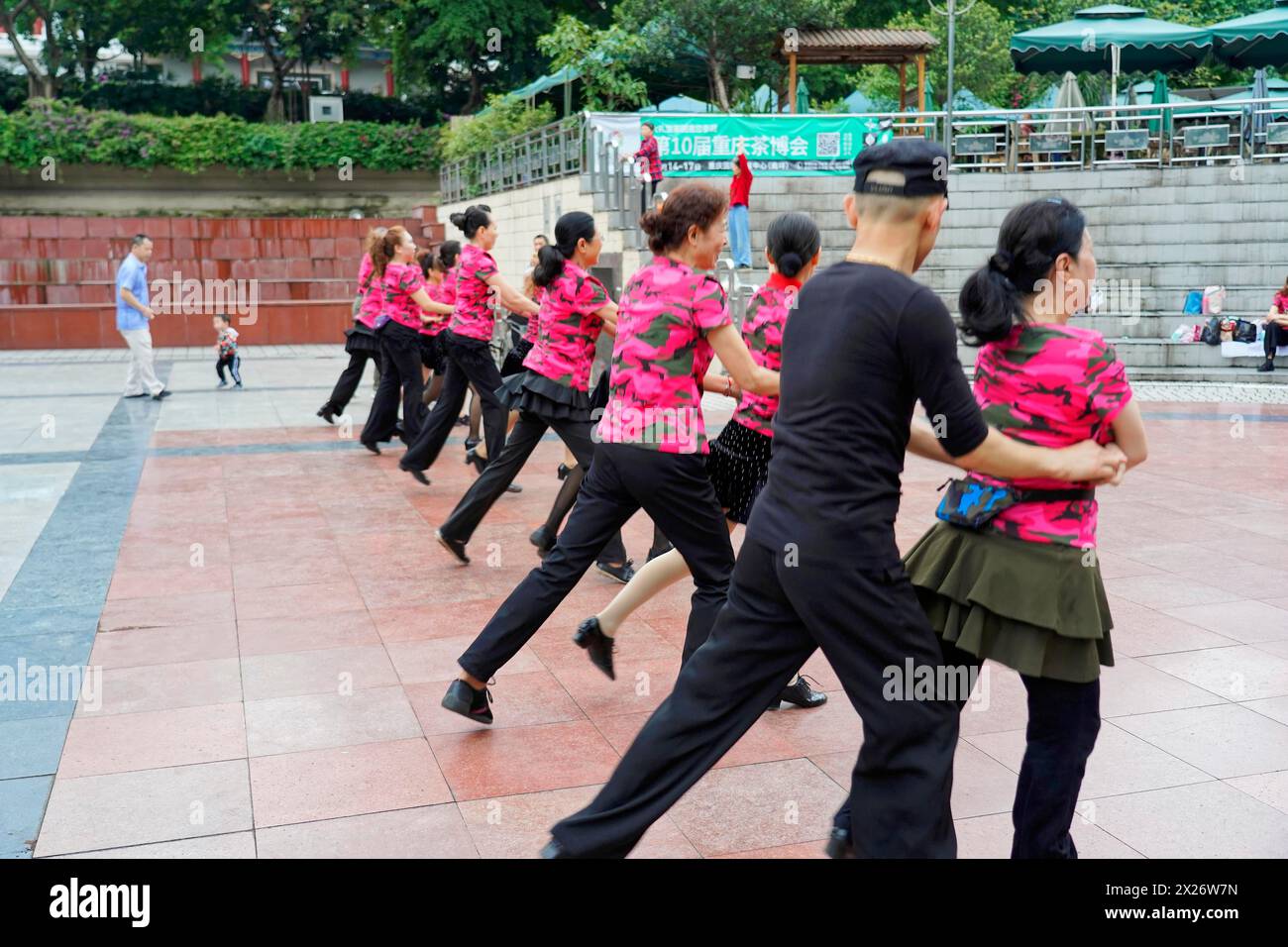 I residenti di Chongqing ballano nel centro della città, Chongqing, Cina, Asia, diverse coppie praticano la danza di strada, vestita in nero e rosa, su una Foto Stock