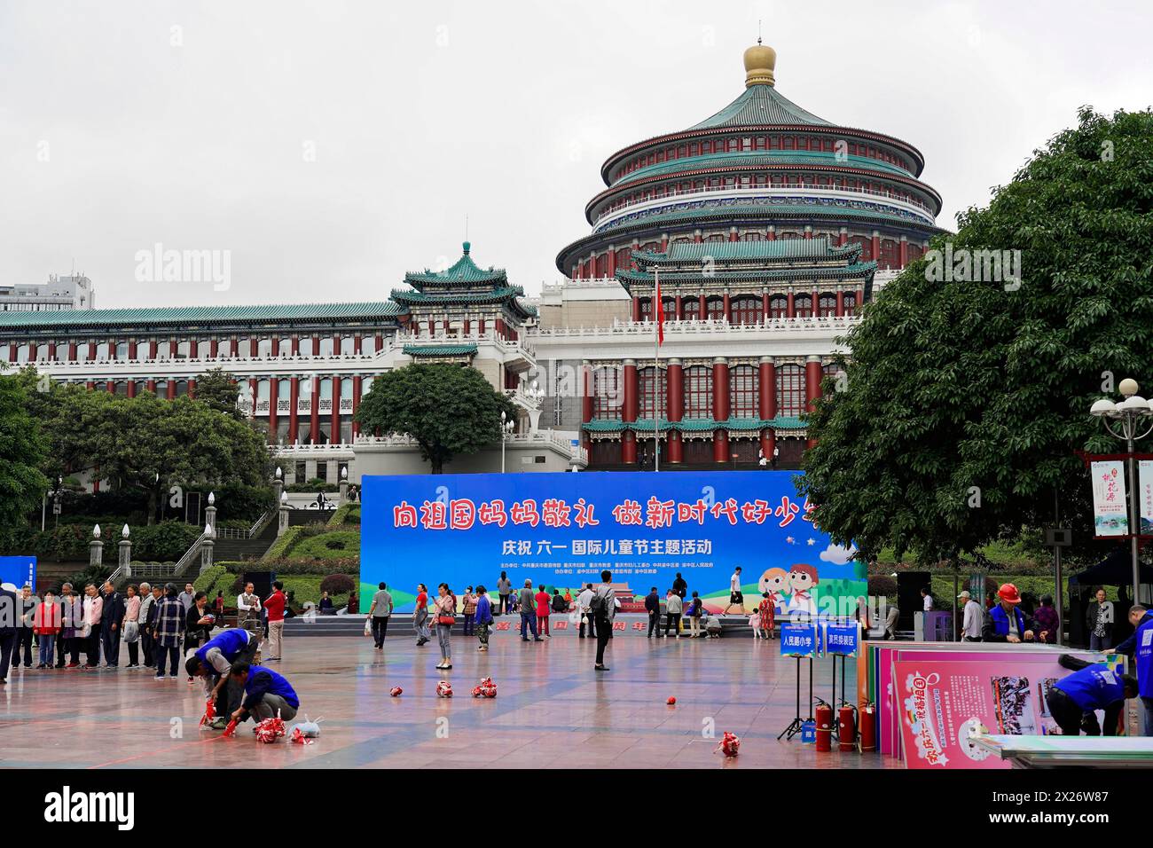 Chongqing, provincia di Chongqing, Cina, Asia, persone in una piazza con un edificio di rilievo sullo sfondo di un evento culturale Foto Stock