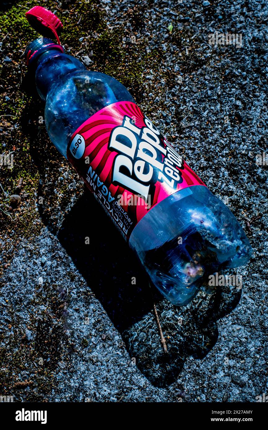 Danni ambientali: Una grande bottiglia di plastica Dr. Pepper scaricata su un sentiero pubblico a Cardiff, Galles. Inquinamento. Lettiera. Spazzatura. Foto Stock