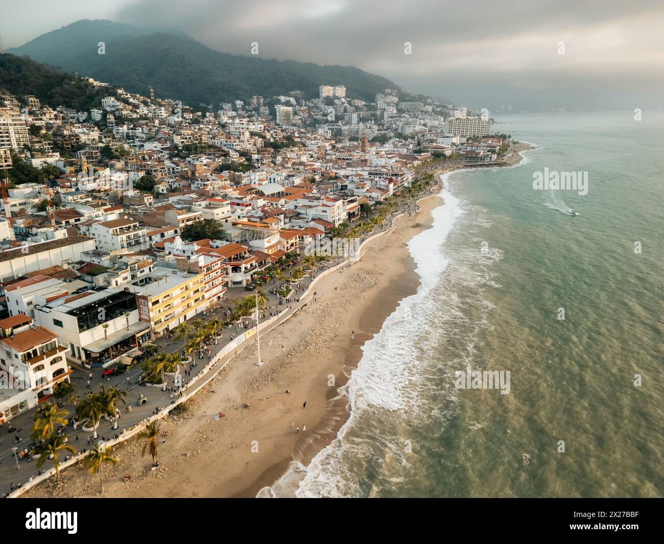 Onde che si infrangono sulla costa al tramonto viste dall'alto di El Malecon Puerto Vallarta, Messico. Foto Stock