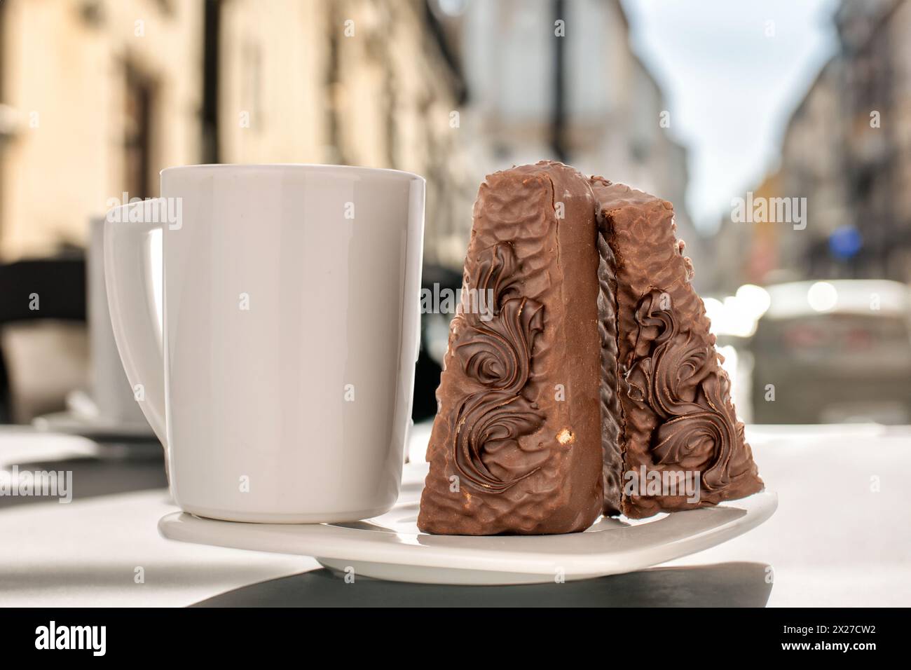 Due fette di torta al cioccolato con piattino bianco in ceramica e tazza sul tavolo nel caffè. Foto Stock