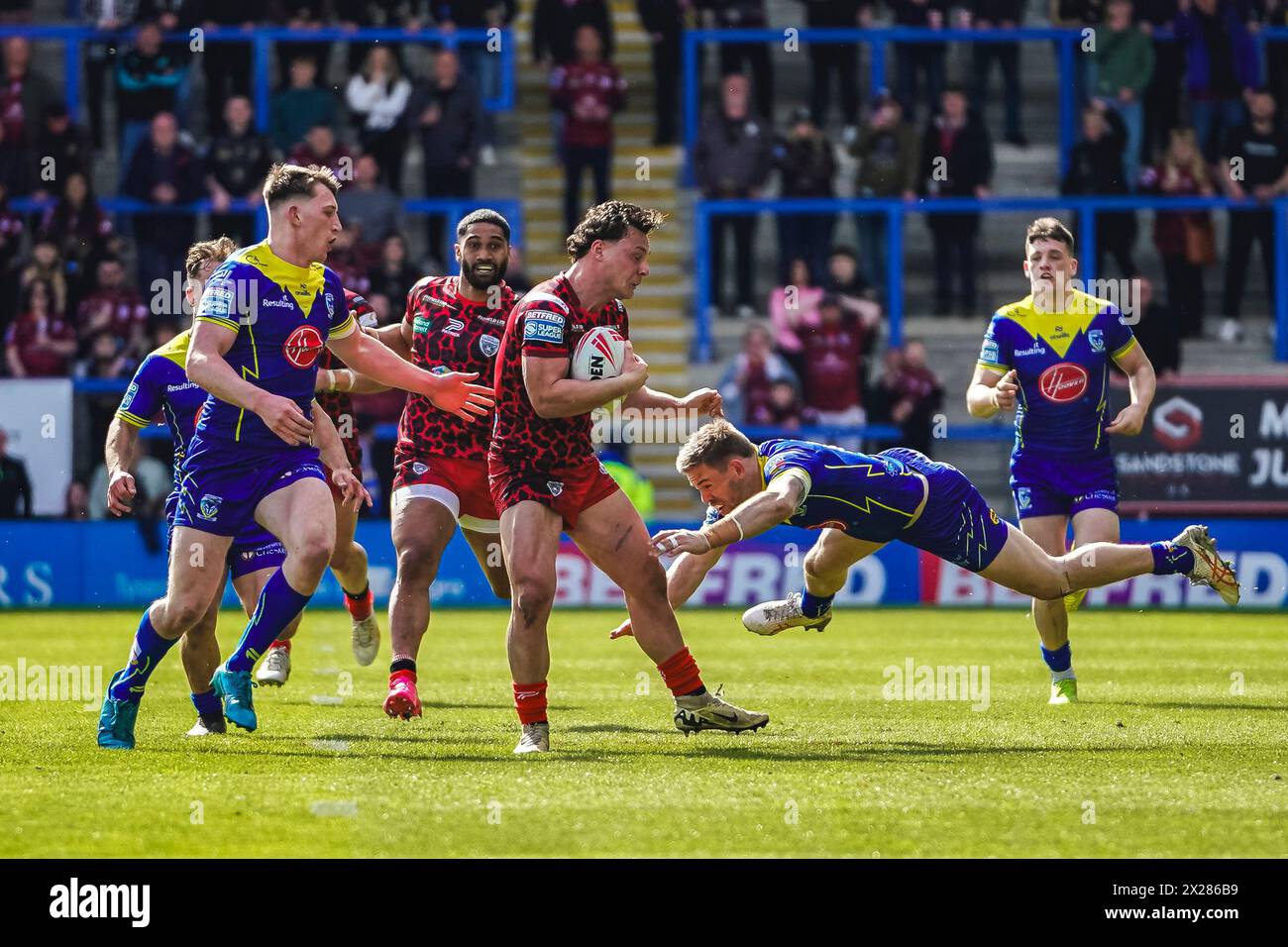 Warrington, Cheshire, Regno Unito. 20 aprile 2024. Super League Rugby: Warrington Wolves vs Leigh Leopards all'Halliwell Jones Stadium. LACHLAN LAM batte un tackle, ma presto si ferma. Credito James Giblin/Alamy Live News. Foto Stock