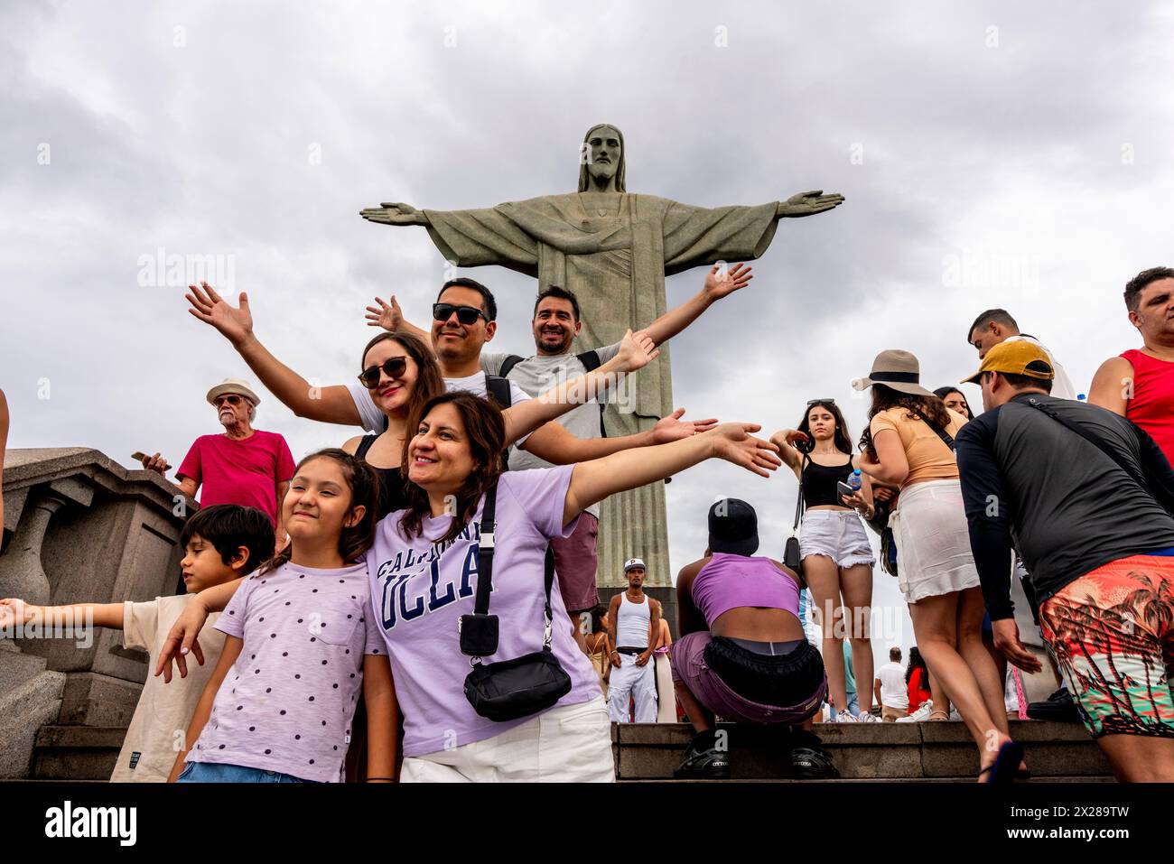 Un gruppo di turisti/visitatori in posa per una foto alla statua del Cristo Redentore, Rio de Janeiro, Brasile. Foto Stock